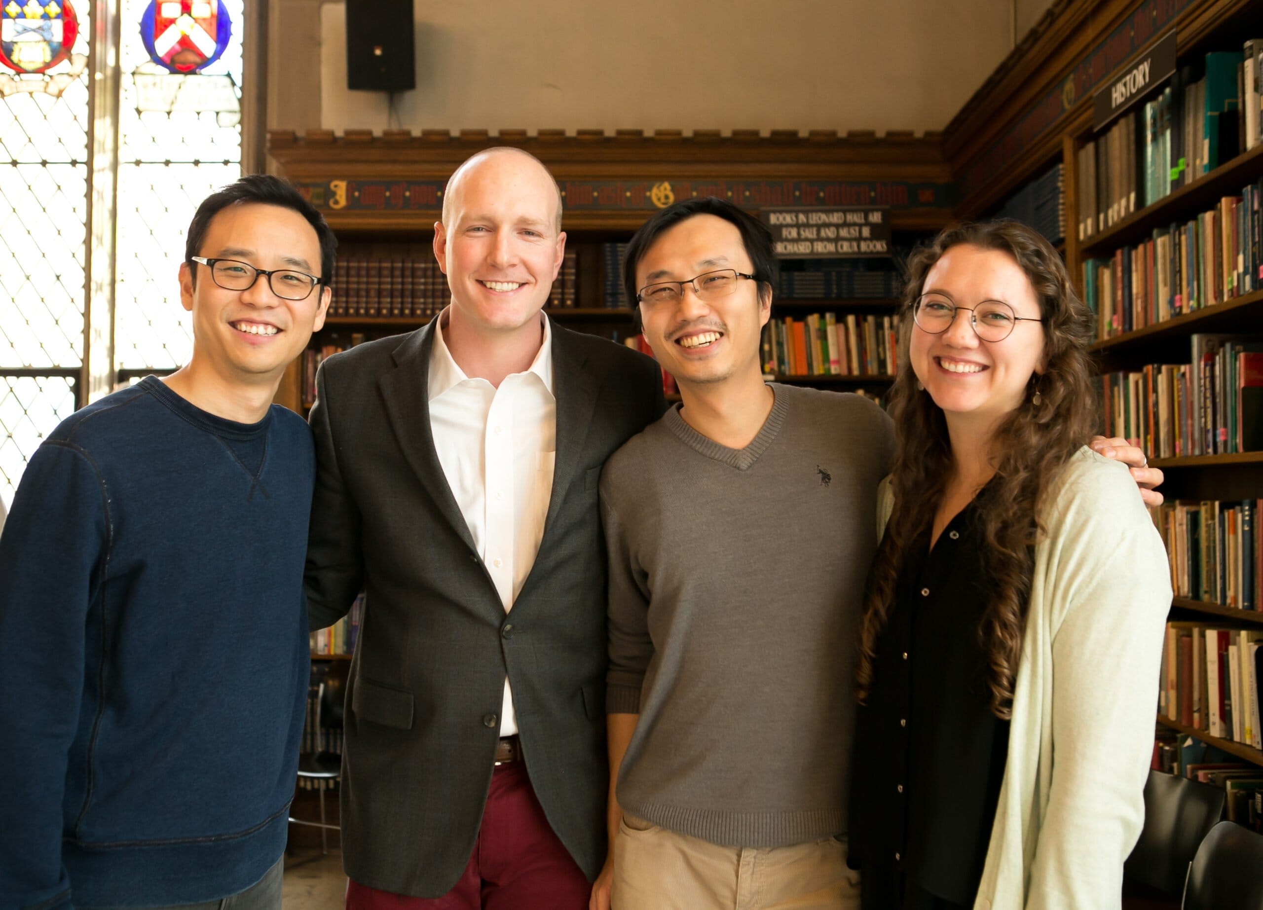 Four professional-looking people in front of a bookshelf with fundraiser content.